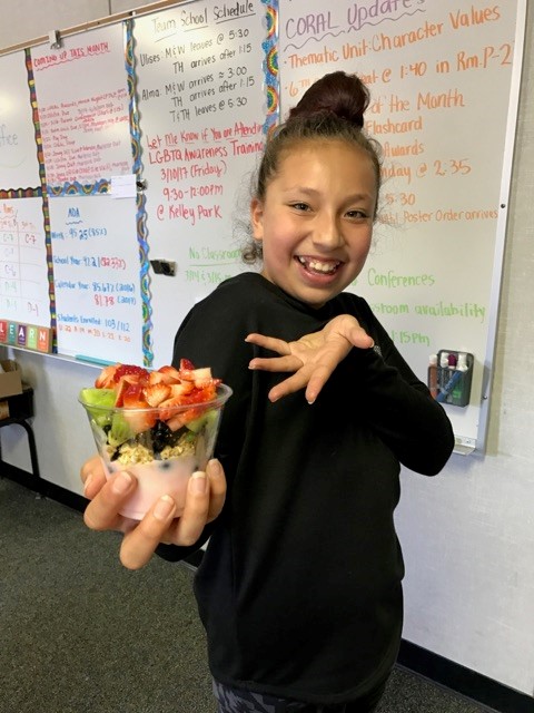 a girl holds a yogurt parfait