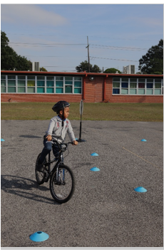 A fourth-grade student at Washington STEM Elementary School riding a bicycle practicing the bike skills drills.