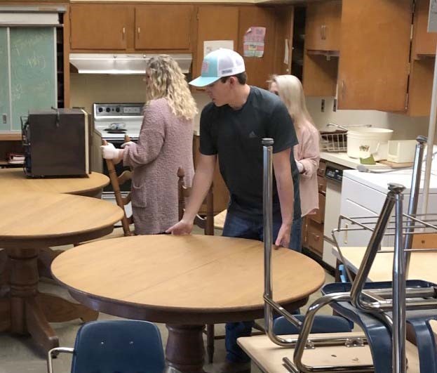 Volunteers set up tables and chairs