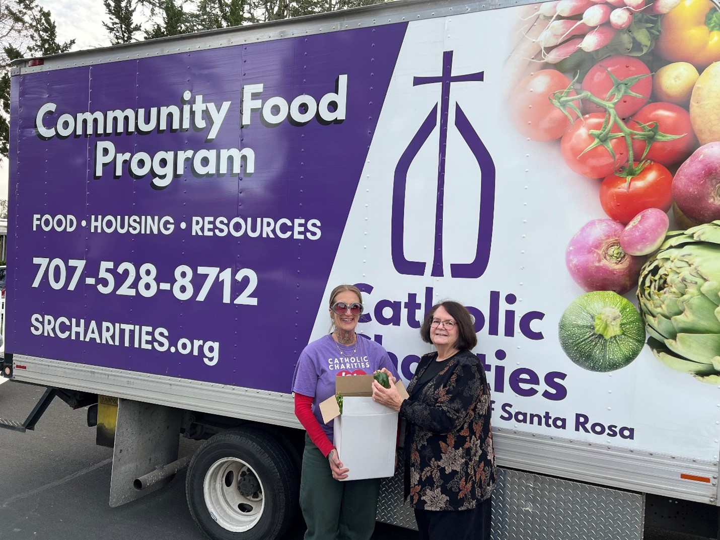 Community Food Program truck with two employees smiling