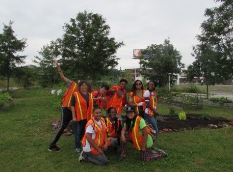 youth posing in front of their garden