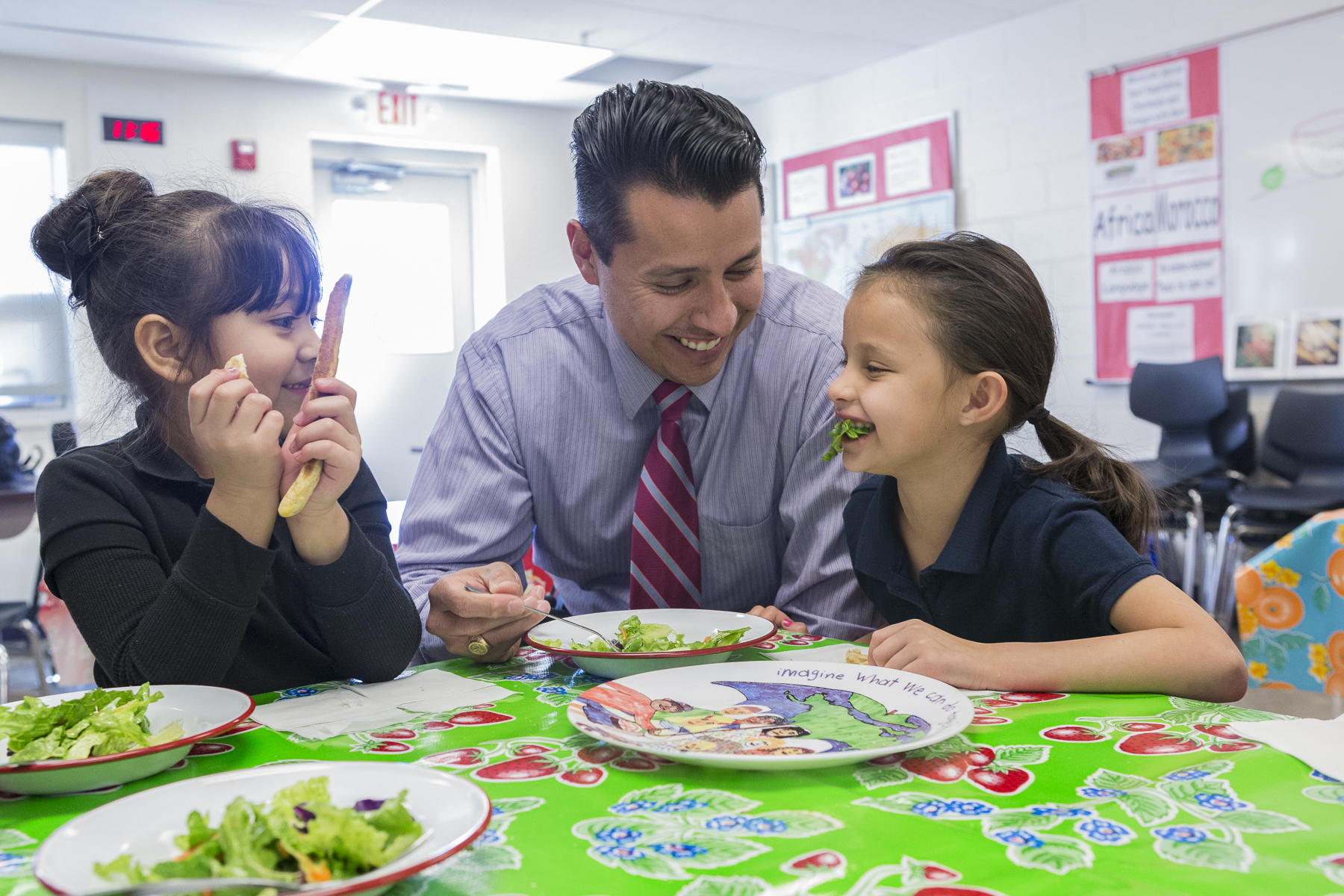 girls laughing at a table with a teacher