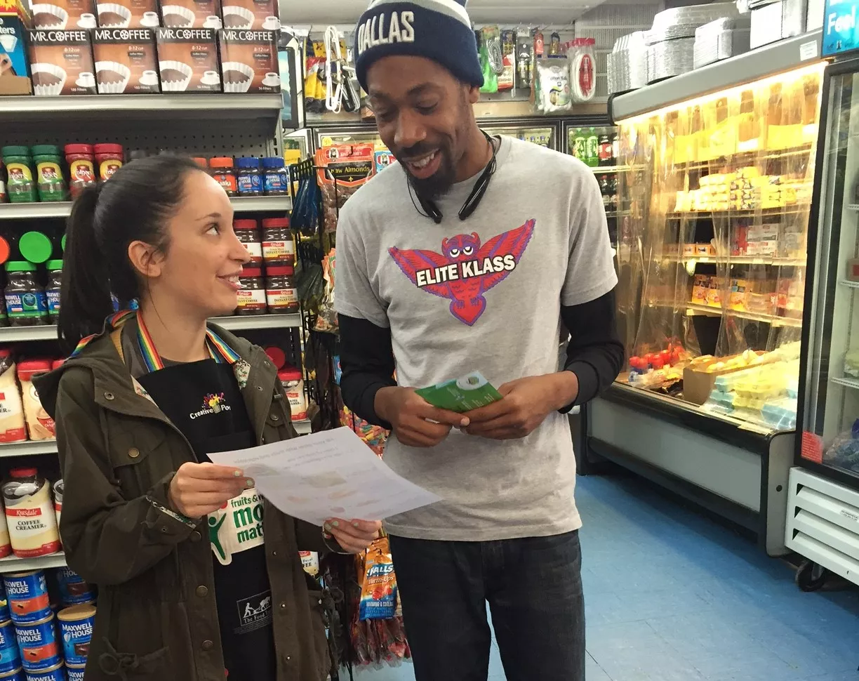 Man talking to a nutrition educator at a convenience store.