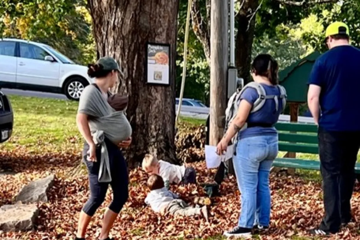 walkers reading a page of a story along the StoryWalks route