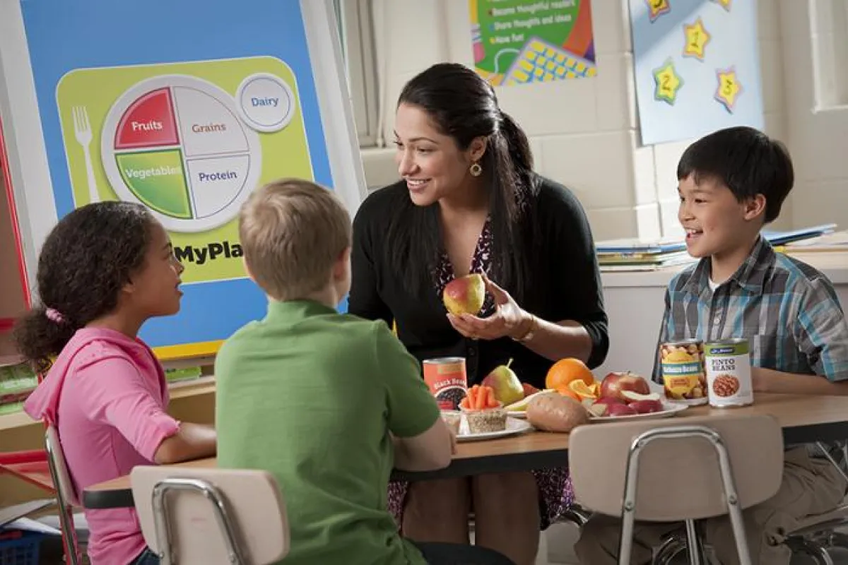 woman teaching nutrition to kids
