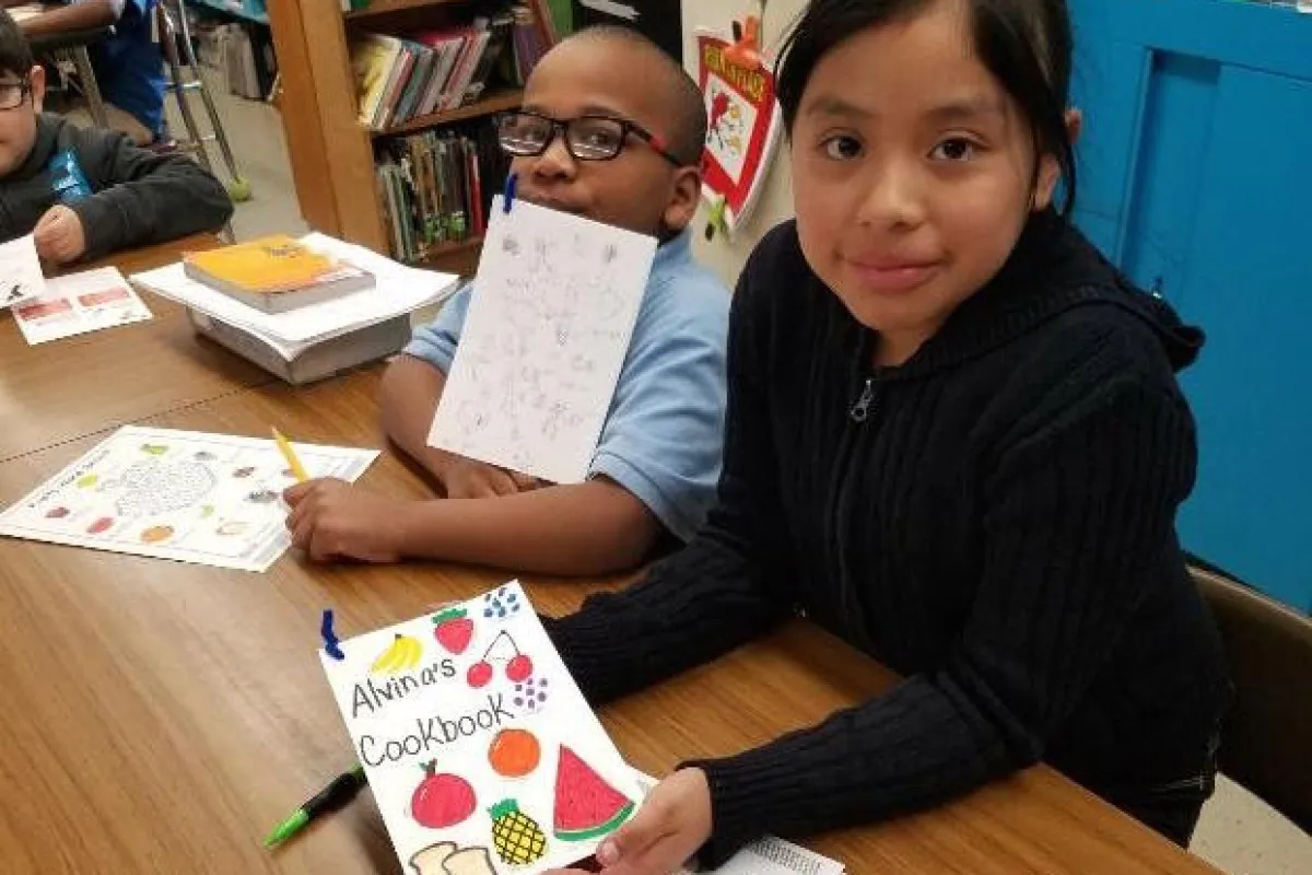 Girl holding up her cookbook