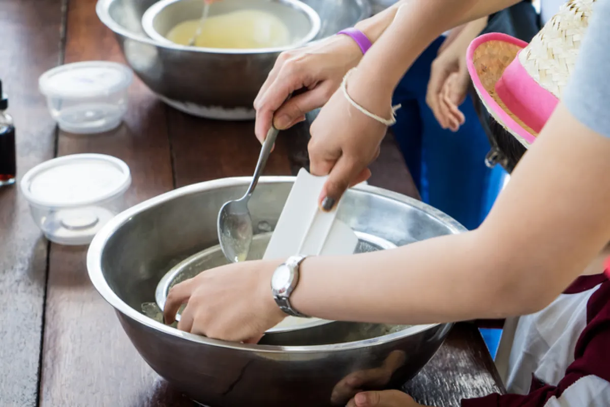 child and adult mixing something in a bowl