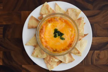 tortilla chips in a circle around a dish of bean dip