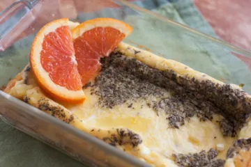 baked eggs and cheese in a baking dish with oranges slices on top