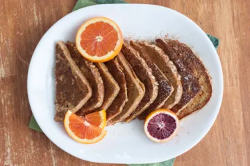 French toast on a plate with orange slices