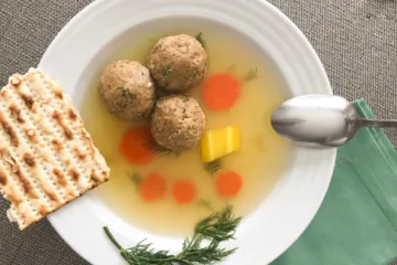 mazto ball soup in a white bowl with a spoon