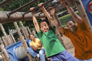 boy plays on monkey bars