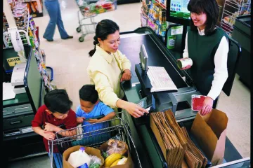 checker helping a woman buy groceries