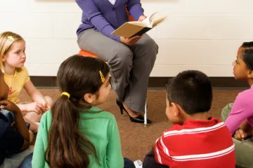 children sitting and listening to a book being read