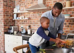 father and son washing vegetables