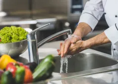 man washing hands in sink
