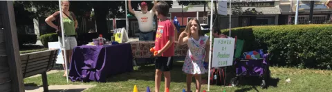 Kids standing with a Power of Produce Club sign