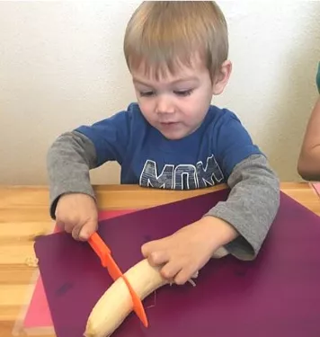 a boy slices a banana