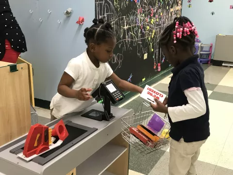 Kids playing at a grocery store check out in an indoor playground