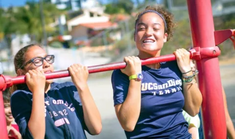 students at a pull up bar in PE class