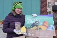 A food pantry worker holds up a sign in Spanish