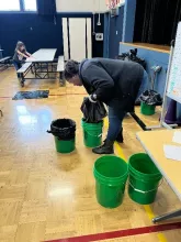 volunteer helps to set up the food waste buckets